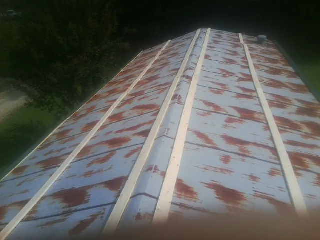 Rusted metal roof panels with new wood purlins before replacement — Storm Damage Roof Repair in Beech Creek by Roofing Brothers