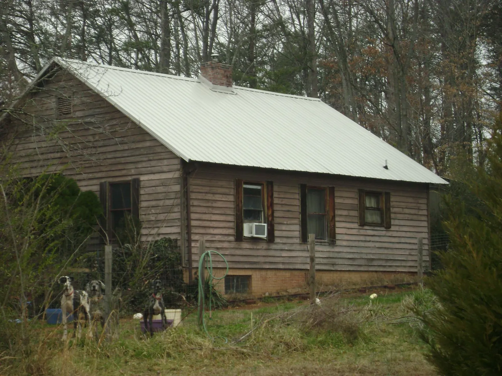 White metal roof on an old wood sided farmhouse, from a Metal Roof Installation job in Beech Creek